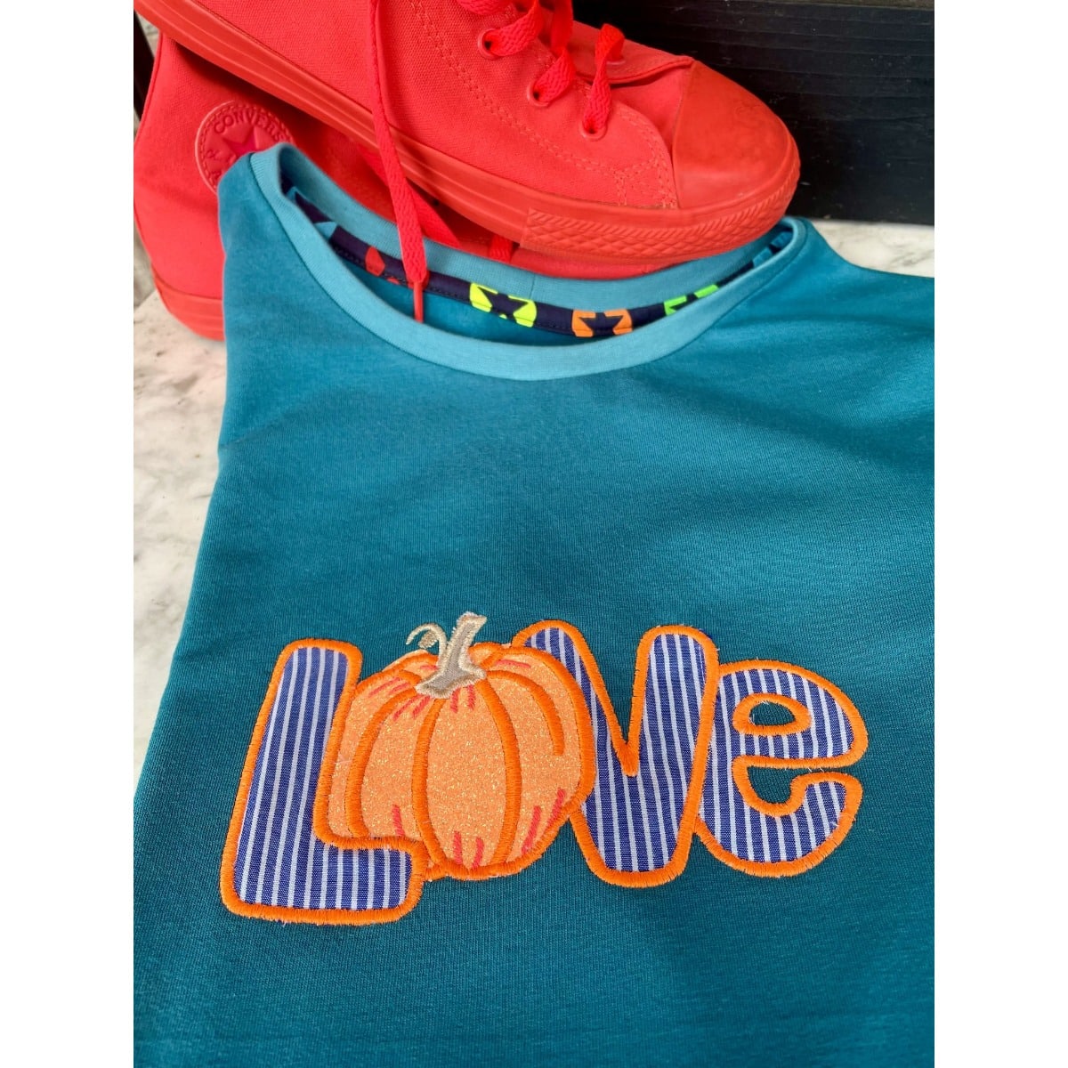 Stickdatei „Kürbis Liebe“ 20 x 30 cm – LOVE-Kürbis auf petrolfarbenem Shirt mit roten Schuhen