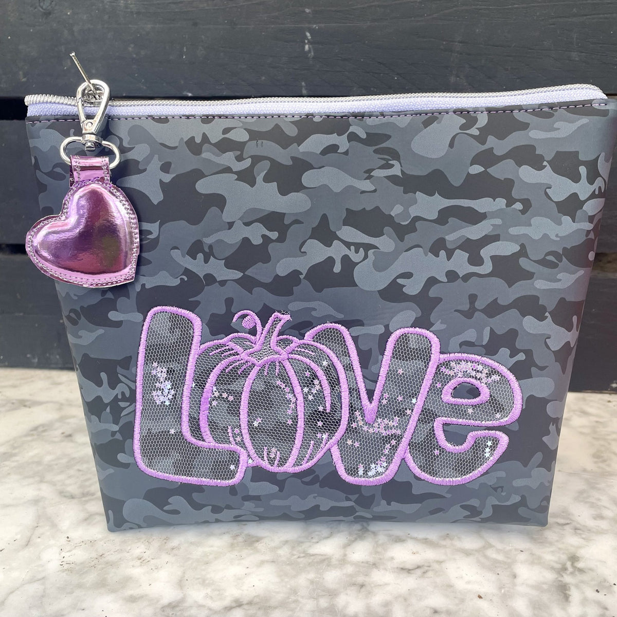 Stickdatei „Kürbis Liebe“ 20 x 30 cm – lila LOVE-Schriftzug auf einer Tasche mit Camouflage-Muster