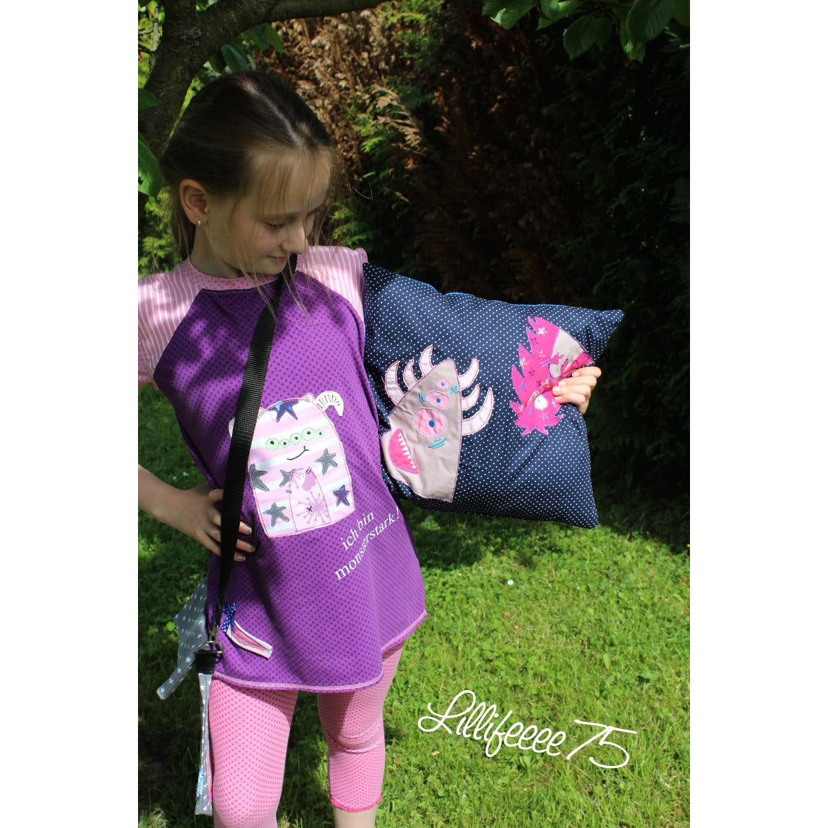 Stickdatei-Serie „Monsterbande“ 13 x 18 cm – Monster auf einem lila Kleid, daneben ein Monsterkissen