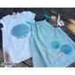 Stickdatei Muschel – weißes Shirt mit großer Applikations-Muschel neben einem Musselin-Top mit zwei kleinen gestickten Muscheln