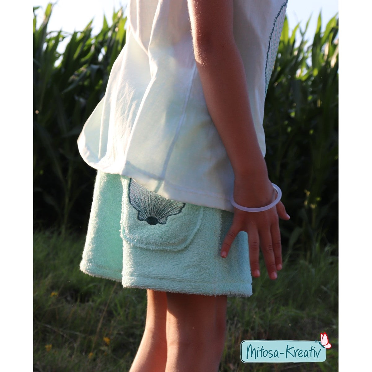 Stickdatei Muschel – mintfarbene Frottee-Shorts mit Muschel auf der Tasche, getragen zum weißen Oberteil