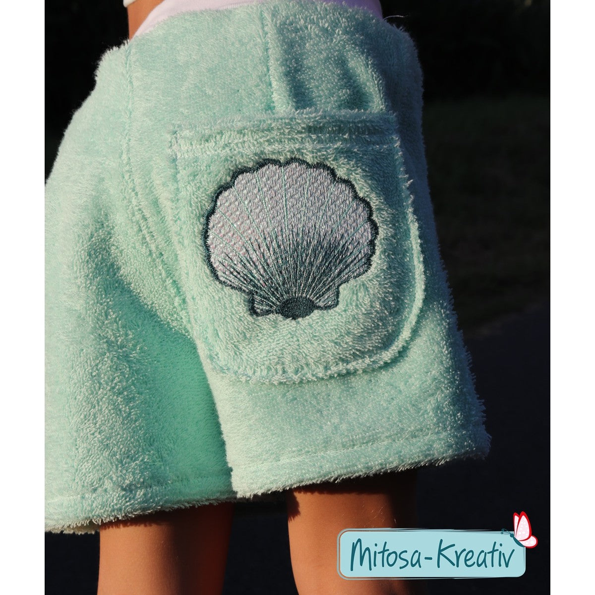 Stickdatei Muschel – mintfarbene Frottee-Shorts mit Folienstick-Muschel auf der Gesäßtasche, Nahaufnahme