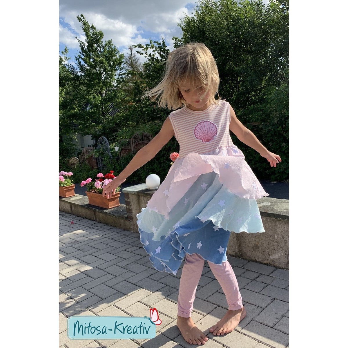 Stickdatei Muschel – Mädchen tanzt in einem rosa-blauen Drehkleid mit Folienstick-Muschel