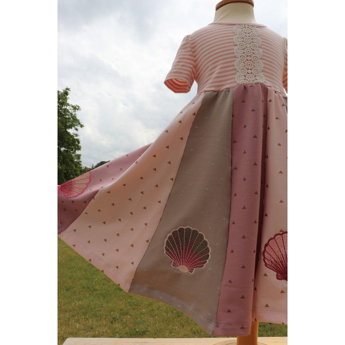 Stickdatei Muschel – Drehkleid aus rosa und grauen Stoffbahnen mit Folienstick-Muscheln am Saum