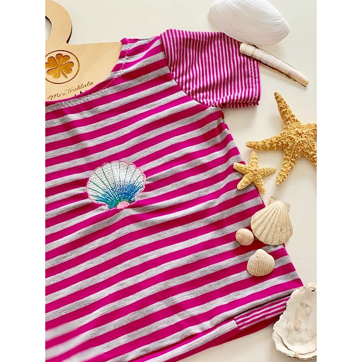 Stickdatei Muschel – pink-grau geringeltes Shirt mit kleiner gestickter Muschel, daneben Seesterne und Muscheln