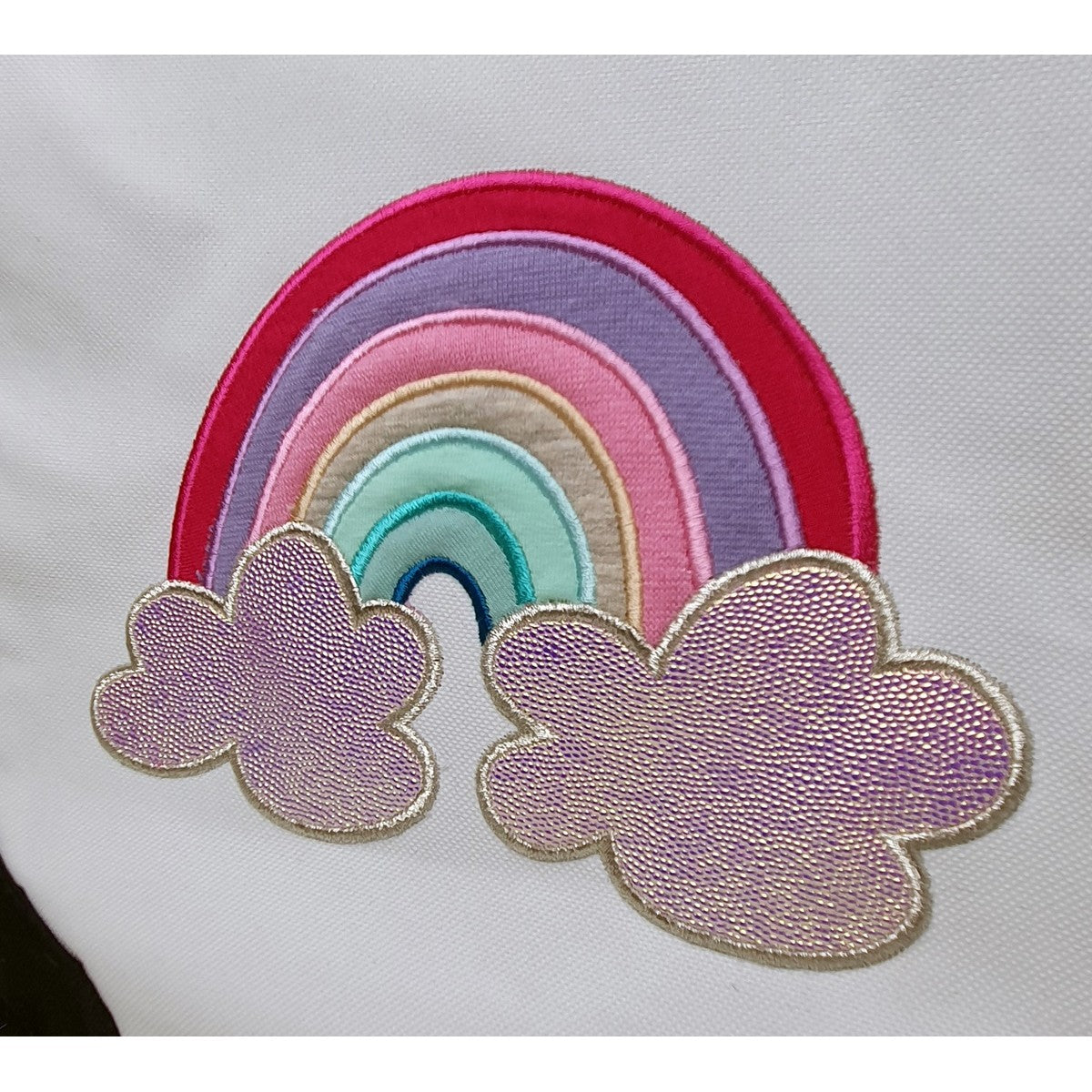 Nahaufnahme der Stickdatei Regenbogen als Satinstich-Applikation mit schimmernden Wolken