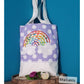 Stickdatei Regenbogen als bunte Applikation auf einem lila gepunkteten Stoffbeutel