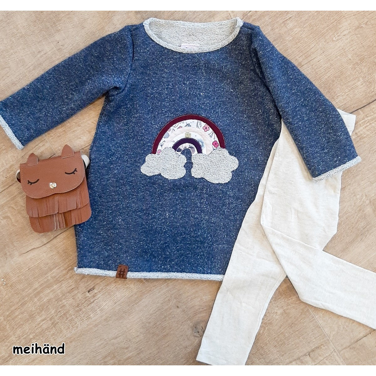 Stickdatei Regenbogen mit Glitzerwolken auf einem blau melierten Kinderkleid