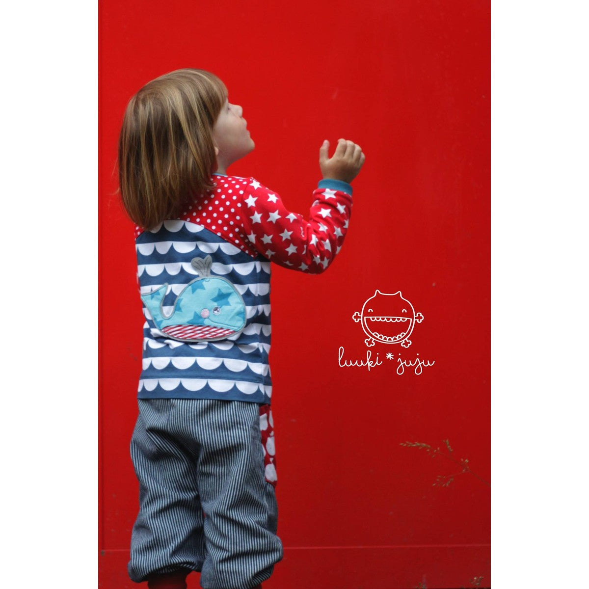 Stickdatei Walfamilie – Kindershirt mit Wellenmuster, auf dem Rücken ein türkiser Lotti Wal mit rot-weiß gestreiftem Bauch