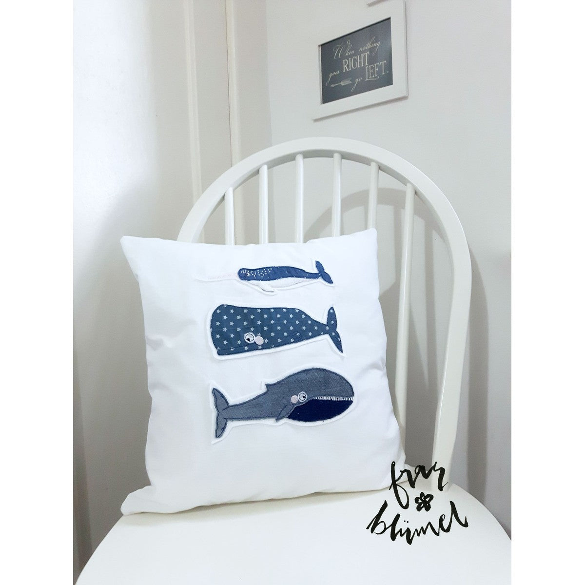 Stickdatei Walfamilie – weißes Kissen mit Narwal, Pottwal und Blauwal aus blauen Stoffen appliziert