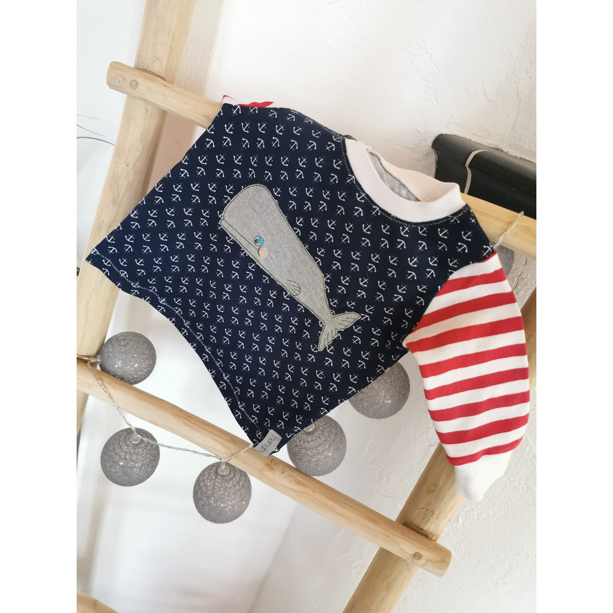 Stickdatei Walfamilie – dunkelblauer Kinderpullover mit Ankermuster, rot-weiß gestreiftem Ärmel und grauem Pottwal als Applikation