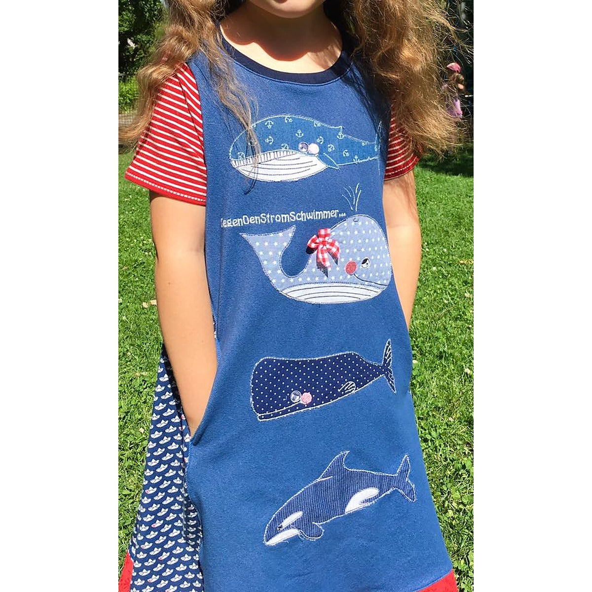 Stickdatei Walfamilie – blaues Sidecut-Kleid mit Eingrifftasche, darauf Blauwal, Lotti Wal mit Schleife, Pottwal und Orca als Applikationen untereinander