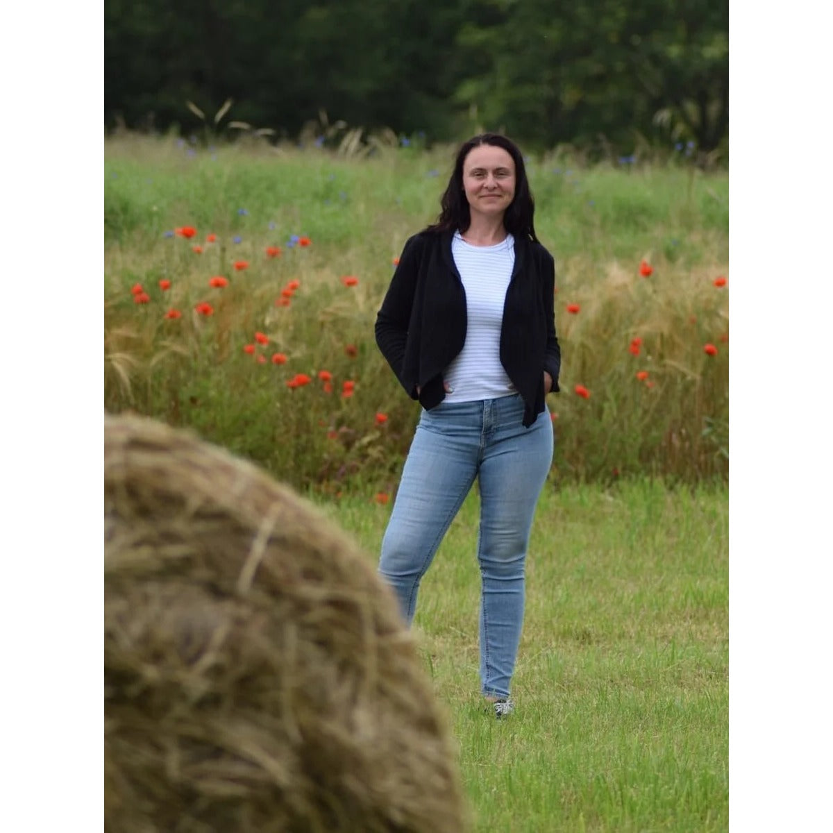 Zipfeljacke Sue Schnittmuster Damen – kurze schwarze Jacke über weißem Shirt, im Feld getragen