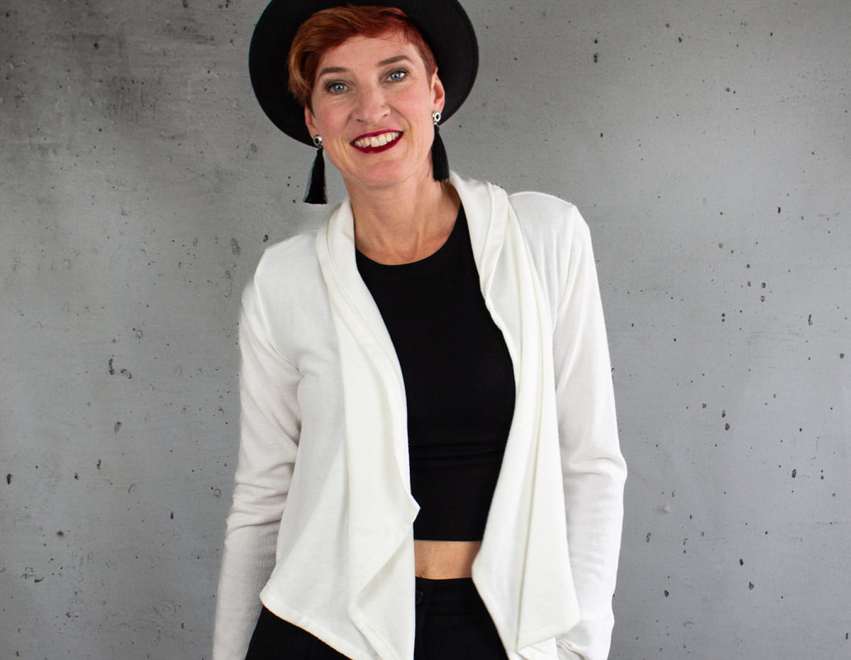 Zipfeljacke Sue Schnittmuster Damen – kurze weiße Jacke offen über einem schwarzen Top getragen